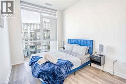 Bedroom featuring a wall of windows and wood finished floors - 