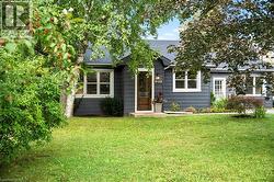 View of front of house with a front yard and a shingled roof - 