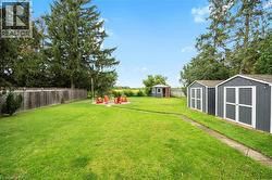 Fenced backyard featuring a storage shed and a fire pit - 