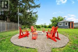 View of playground with a fenced backyard, an outdoor fire pit, and a patio area - 