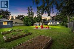 Fenced backyard featuring a patio, a storage shed, and a garden - 