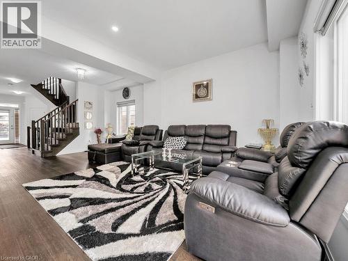 Living room featuring stairs, plenty of natural light, and wood-type flooring - 30 Times Square Boulevard, Hamilton, ON - Indoor Photo Showing Living Room