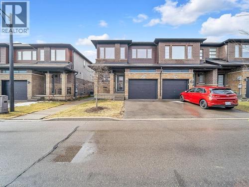 View of front of home featuring driveway, brick siding, and an attached garage - 30 Times Square Boulevard, Hamilton, ON - Outdoor With Facade