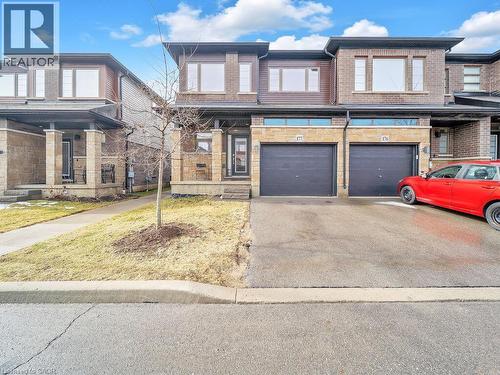View of front of property featuring brick siding, driveway, and an attached garage - 30 Times Square Boulevard, Hamilton, ON - Outdoor With Facade