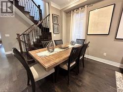 Dining room with ornamental molding, dark wood-type flooring, and stairway - 
