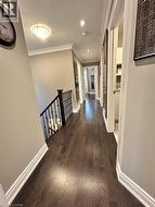 Hallway with crown molding, dark wood-style floors, an upstairs landing, and recessed lighting - 
