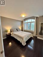 Bedroom featuring dark wood-style flooring and baseboards - 