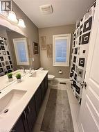 Full bath featuring curtained shower, light tile patterned floors, and double vanity - 