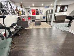 Living room featuring dark wood-style flooring and recessed lighting - 