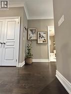 Hall featuring crown molding and dark wood-style floors - 