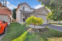 Traditional-style home with brick siding, asphalt driveway, and an attached garage - 