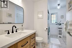 Bathroom featuring light tile patterned flooring, vanity, and a shower with shower curtain - 