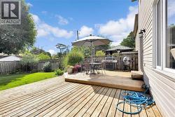 Wooden terrace with outdoor dining area, a fenced backyard, a grill, and a gazebo - 