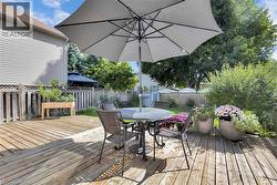 Deck with outdoor dining space, a fenced backyard, and a storage shed - 