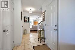 Corridor featuring arched walkways and light tile patterned flooring - 