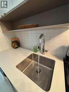 View of decorative tiled backsplash, quartz counters & Upgraded Faucet - 