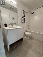 Full bath with RainShower head, white tiled walls and a spacious 2-tone Vanity on tiled floors - 