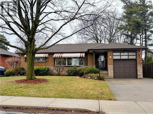 Ranch-style home with driveway, a front yard, an attached garage, and brick siding - 98 Laurier Avenue, Hamilton, ON 