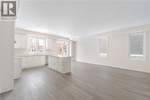 Kitchen with sink, light wood-type flooring, white cabinets, and a kitchen island - 109 Molozzi Street, Erin, ON - Indoor Photo Showing Kitchen
