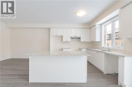 Kitchen with white cabinetry, a center island, sink, and light hardwood / wood-style flooring - 109 Molozzi Street, Erin, ON - Indoor Photo Showing Kitchen