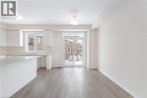 Kitchen with white cabinetry, a healthy amount of sunlight, sink, and light wood-type flooring - 109 Molozzi Street, Erin, ON - Indoor Photo Showing Kitchen