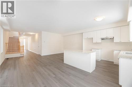 Kitchen with light hardwood / wood-style flooring, sink, a kitchen island, and white cabinets - 109 Molozzi Street, Erin, ON - Indoor Photo Showing Kitchen