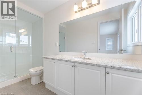 Bathroom with tile patterned flooring, vanity, a shower with door, and toilet - 109 Molozzi Street, Erin, ON - Indoor Photo Showing Bathroom