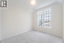 Empty room featuring light carpet and vaulted ceiling - 
