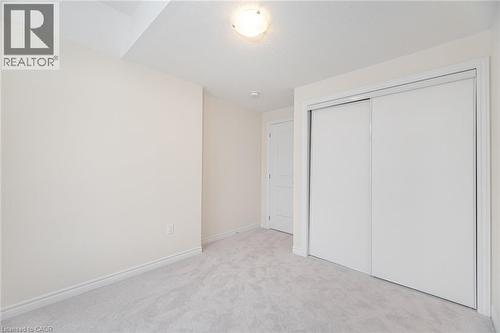 Unfurnished bedroom featuring light carpet and a closet - 109 Molozzi Street, Erin, ON - Indoor Photo Showing Other Room