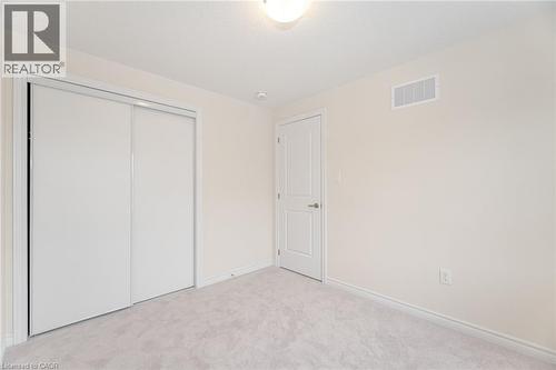 Unfurnished bedroom featuring light colored carpet and a closet - 109 Molozzi Street, Erin, ON - Indoor Photo Showing Other Room