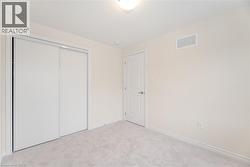 Unfurnished bedroom featuring light colored carpet and a closet - 