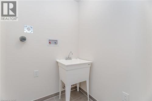 Clothes washing area featuring washer hookup and light tile patterned floors - 109 Molozzi Street, Erin, ON - Indoor
