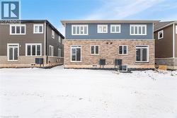 Snow covered back of property featuring central air condition unit - 