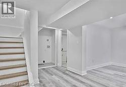 Finished basement featuring stairs and light wood-style floors - 