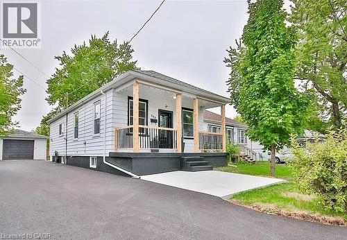 View of front of home featuring an outbuilding, covered porch, and a garage - 549 Waterloo Street, Hamilton, ON - Outdoor With Deck Patio Veranda