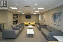 Carpeted living area with a paneled ceiling and recessed lighting - 