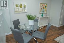 Dining room featuring dark wood-type flooring and baseboards - 