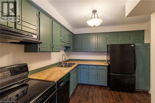 Kitchen featuring black appliances, under cabinet range hood, dark wood-style floors, and butcher block counters - 58 Romy Crescent, Thorold, ON - Indoor Photo Showing Kitchen With Double Sink