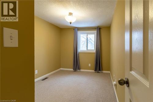 Unfurnished room featuring a textured ceiling and light carpet - 58 Romy Crescent, Thorold, ON - Indoor Photo Showing Other Room