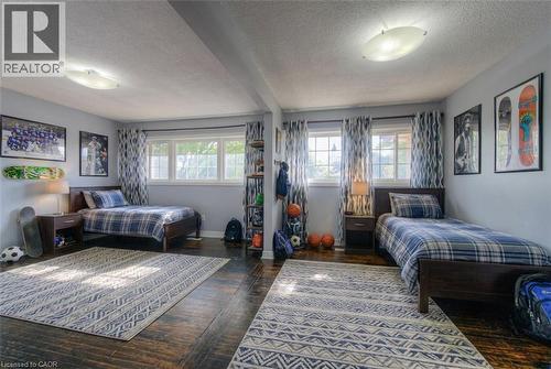 Bedroom with dark wood-style flooring, multiple windows, beamed ceiling, and a textured ceiling - 46 Guerin Avenue, Kitchener, ON - Indoor Photo Showing Bedroom