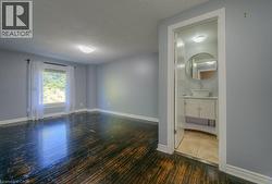 Empty room featuring dark wood-style floors and a textured ceiling - 
