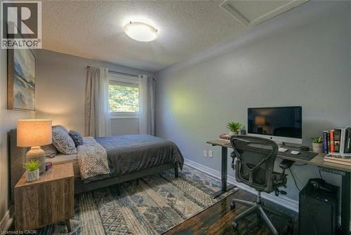 Bedroom featuring a textured ceiling, wood finished floors, and a desk - 46 Guerin Avenue, Kitchener, ON - Indoor Photo Showing Bedroom