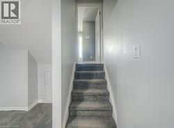 Staircase featuring carpet flooring and baseboards - 