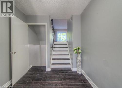 Staircase with wood tiled floors and a textured ceiling - 46 Guerin Avenue, Kitchener, ON - Indoor Photo Showing Other Room