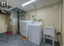 Laundry area featuring heating unit, washer and dryer, and gas water heater - 
