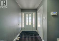 Doorway featuring wood finish floors and a textured ceiling - 