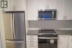 Kitchen with appliances with stainless steel finishes and white cabinets - 