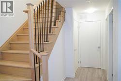 Staircase with wood finished floors and baseboards - 