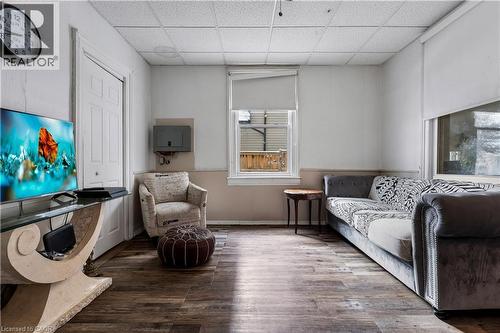 Living area with wood finished floors and a paneled ceiling - 193 Locke Street N, Hamilton, ON - Indoor Photo Showing Living Room
