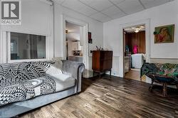 Living area featuring a drop ceiling, wood finished floors, and a ceiling fan - 